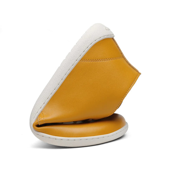 Zapato minimalista hombre Saguaro Noble I amarillo torsionado demostrando flexibilidad.