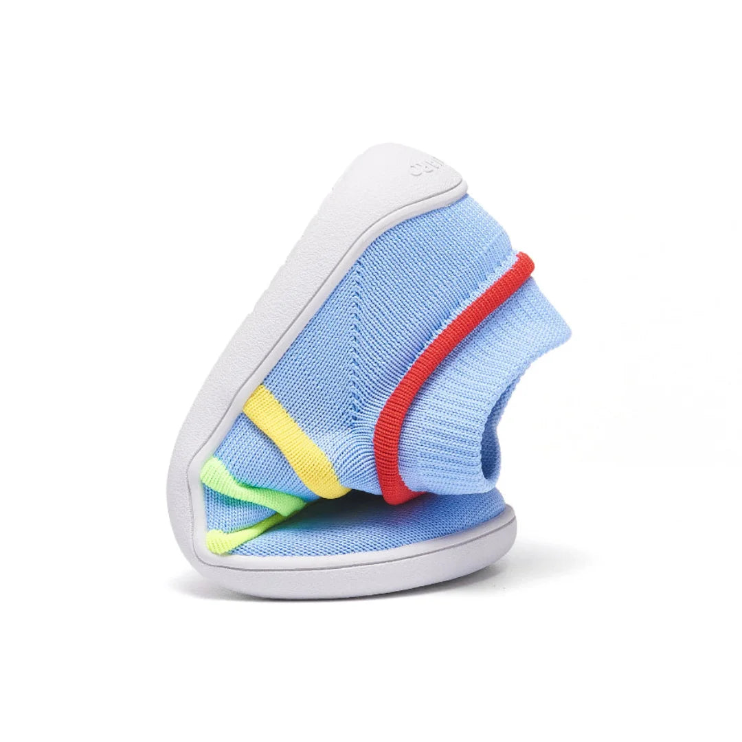 Zapatilla infantil azul doblada mostrando su total flexibilidad.
