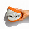 Zapatilla barefoot gris doblada demostrando su gran flexibilidad.