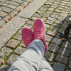Persona usando zapatillas Saguaro Luck II fucsia en la ciudad.