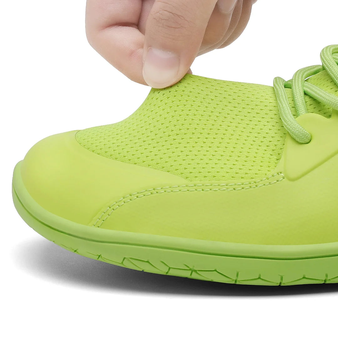 Mano estirando la malla técnica de la zapatilla para mostrar flexibilidad y ventilación.