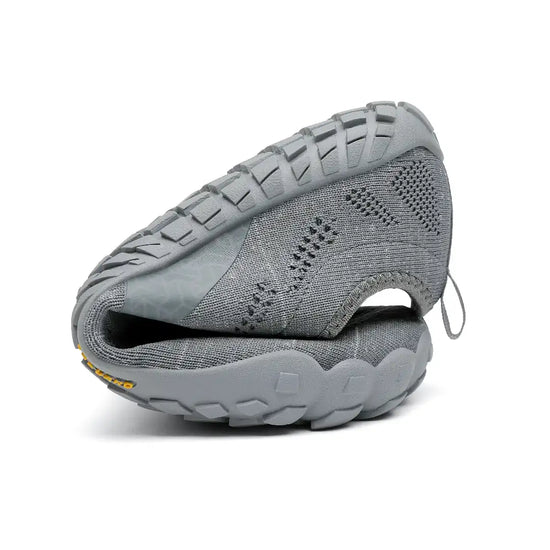 Saguaro Smart I grises dobladas demostrando flexibilidad natural barefoot.