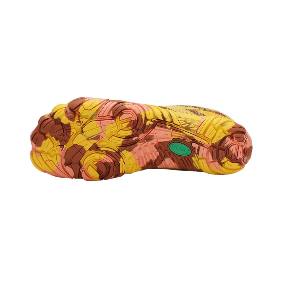 Suela de caucho flexible con diseño de camuflaje naranja y café para máxima tracción.