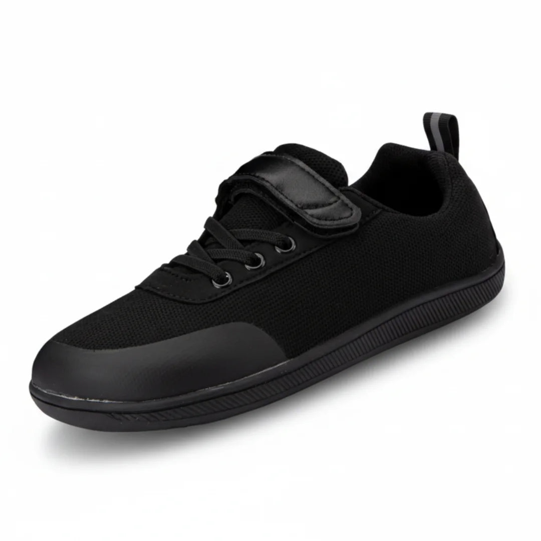 Zapato escolar barefoot negro para niño con puntera reforzada y suela flexible.