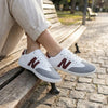 Persona usando zapatillas ZZfaber Niza I blanco con vinotinto en exterior.
